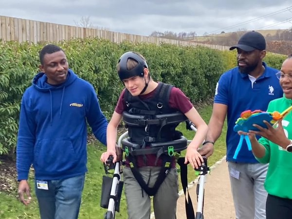 Max walking with therapy team