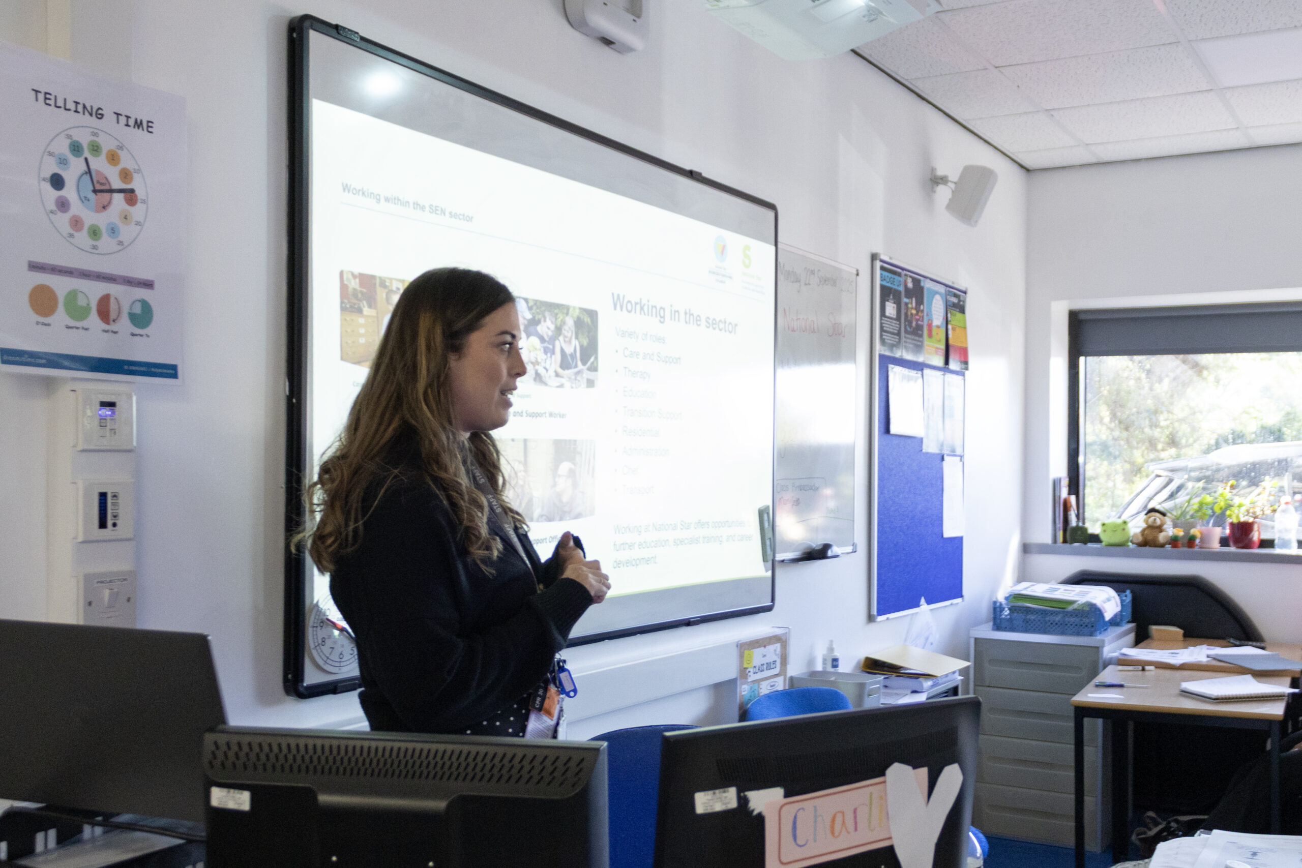 Staff member presenting at the front of a classroom 