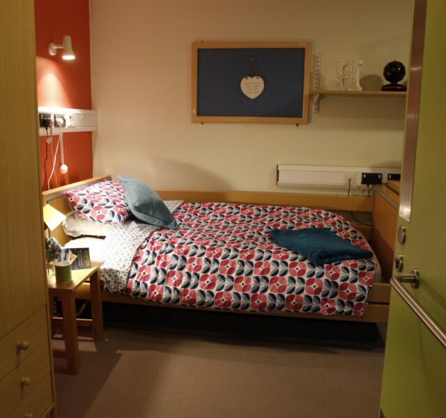 Single bed with multi-colour duvet and drawers