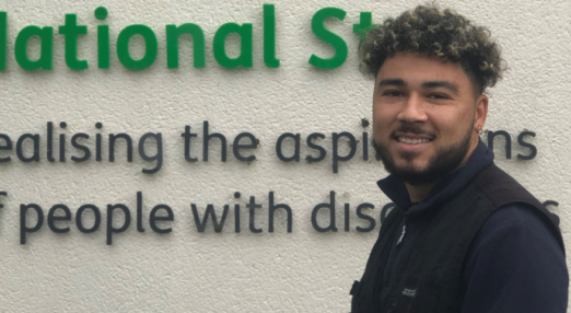 David smiling with the National Star logo in the background