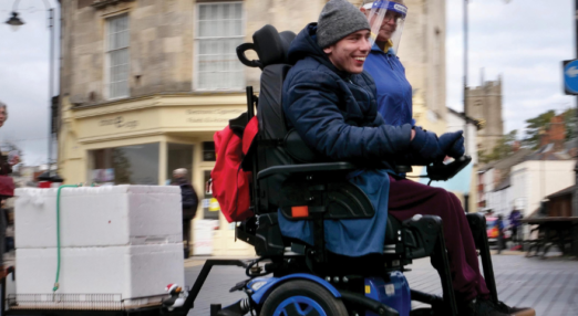 Ed smiling making deliveries in his wheelchair