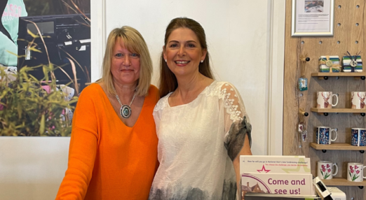 Smiling female charity shop volunteers