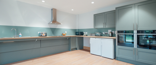 Accessible kitchen featuring ovens, fridge, accessible worktops