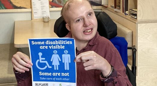 Sam proudly holding up his disability campaign sticker