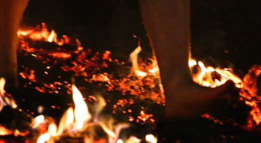 Photo of person completing a firewalk, walking across coals