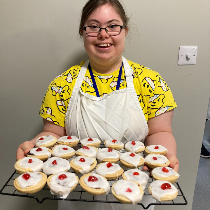 Student smiling holding iced buns