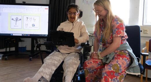 Gurpreet and Poppy smiling in classroom setting