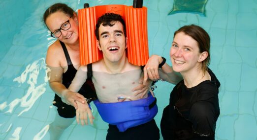 Dan C and physios smiling in aquatic therapy