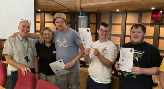 Students smiling holding up their certificate