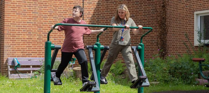Connor and staff member Jess using gym equipment