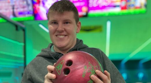 Peter smiling holding a bowling ball