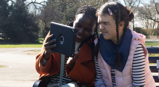 Poppy smiling using a device with staff member
