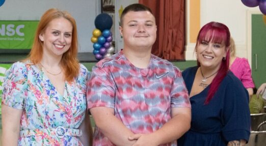 Becca, Tiaan and Hayley smiling at the Wales leavers ceremony under the balloon arch